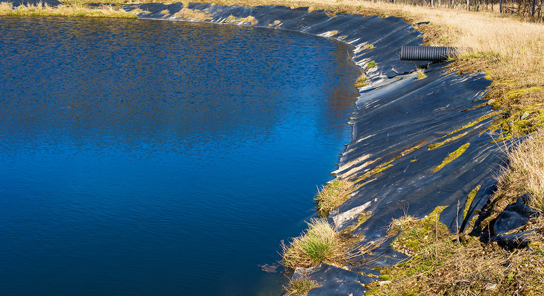 Leachate pond with synthetic lining and surrounding fence. Location Ronneby, Sweden.